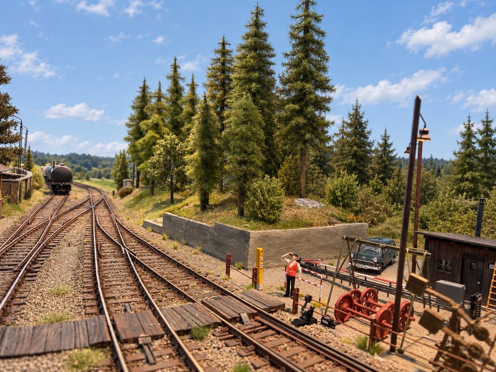 Naaldbomen van Waldwerk langs het spoor op een modelbaan
